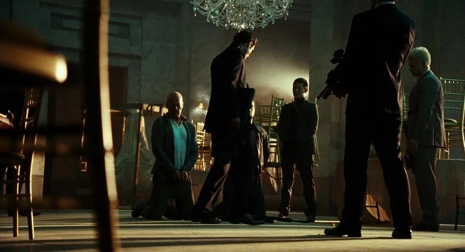A Good Day to Die Hard (2013) movie still: wide — A spacious room with stone walls and a crystal chandelier hanging from the ceiling. Multiple armed…