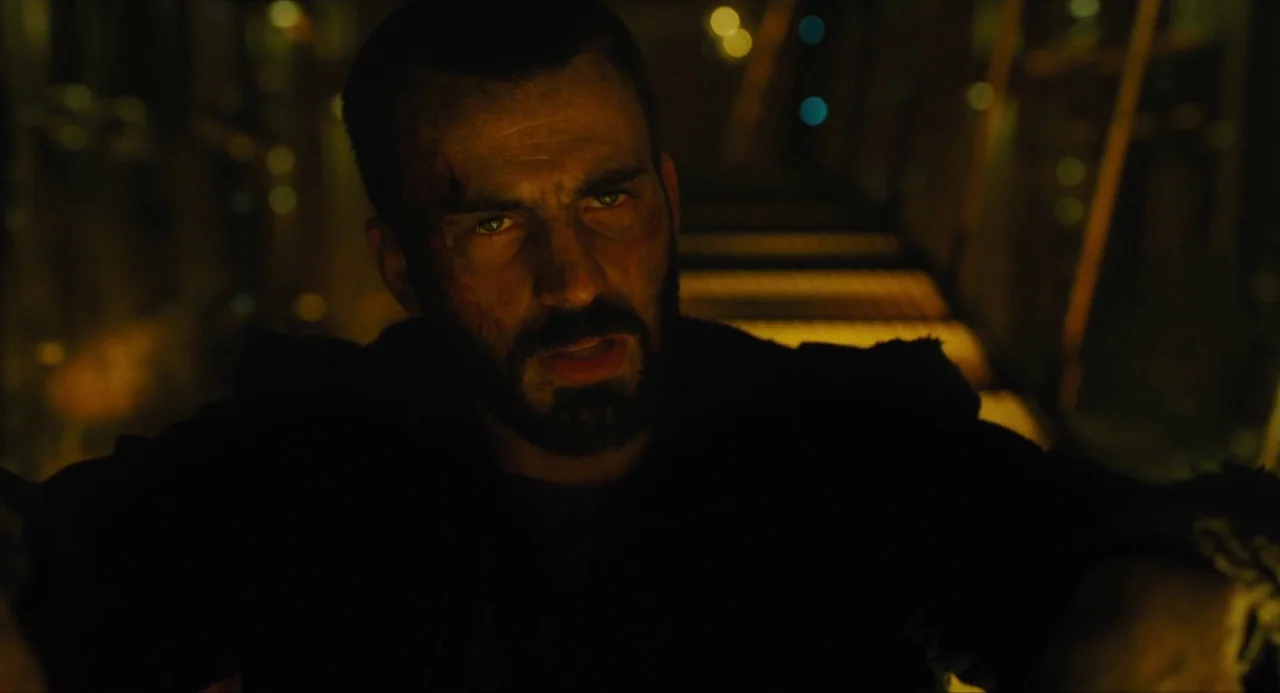 Snowpiercer (2013) movie still: closeup — A dark, industrial-style stairwell with metallic treads and out-of-focus background lights. A man with a…